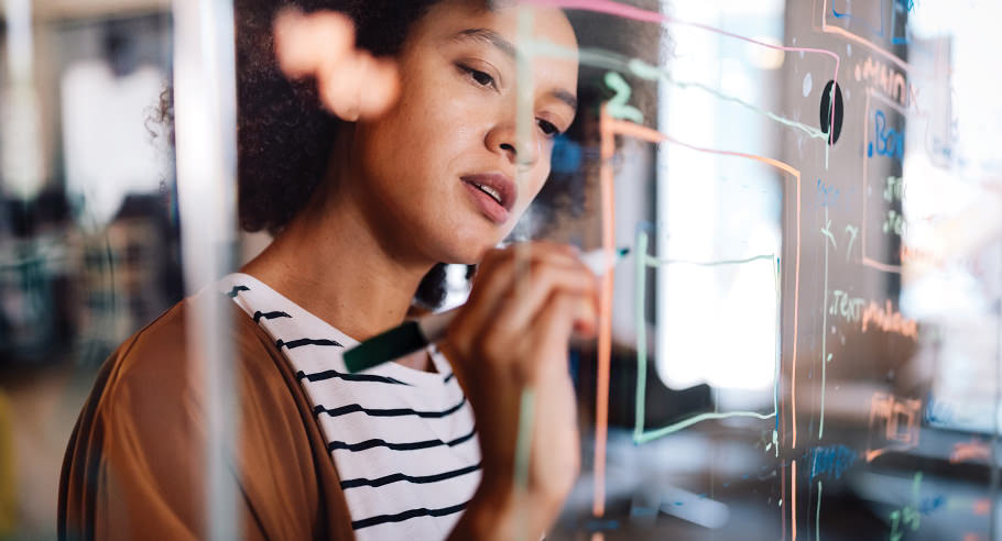 Woman writing on transparent white board